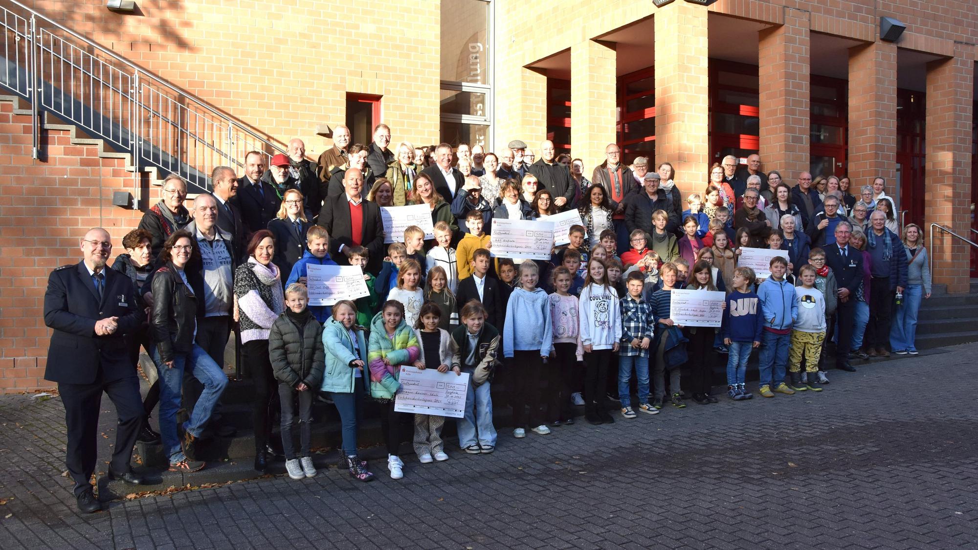 Kinder, Jugendliche und Erwachsene haben sich für das Foto vor ein Gebäude gestellt.