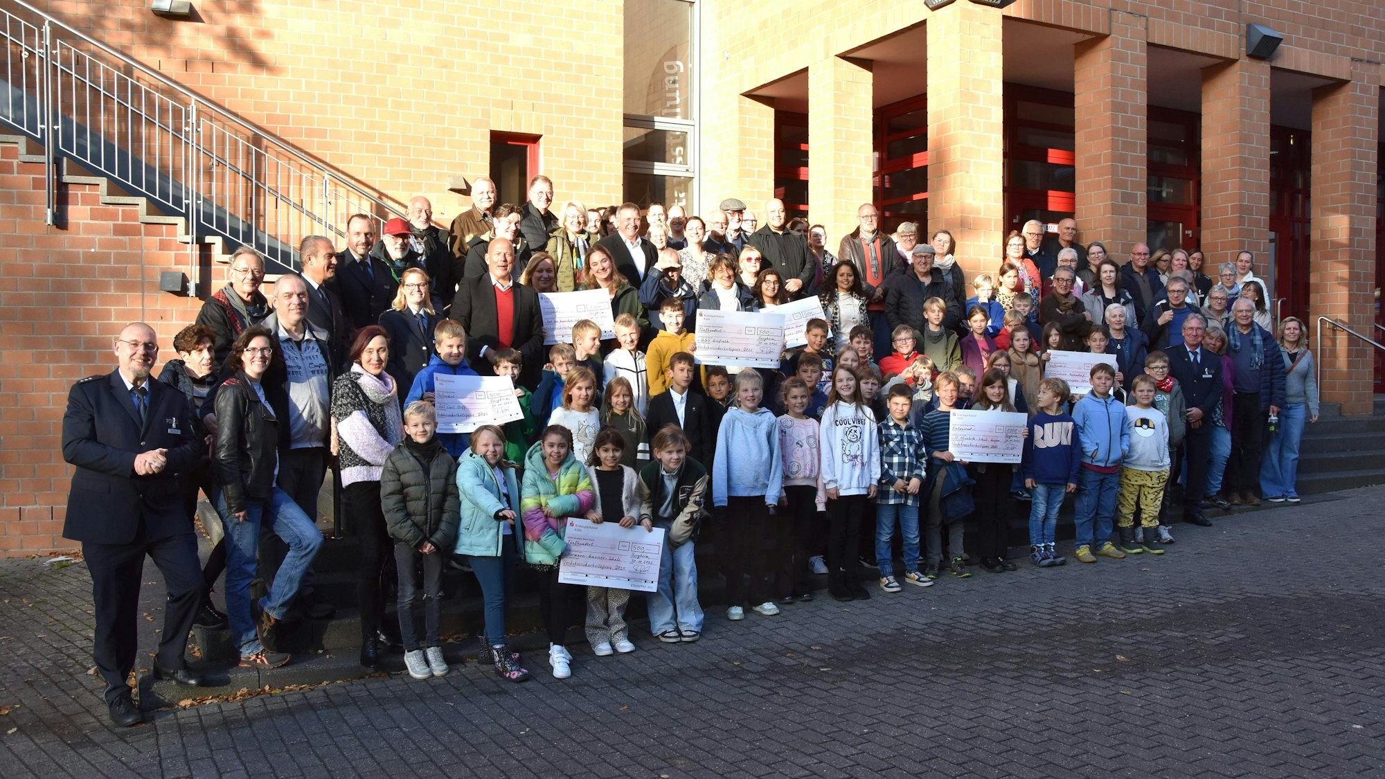 Kinder, Jugendliche und Erwachsene haben sich für das Foto vor ein Gebäude gestellt.