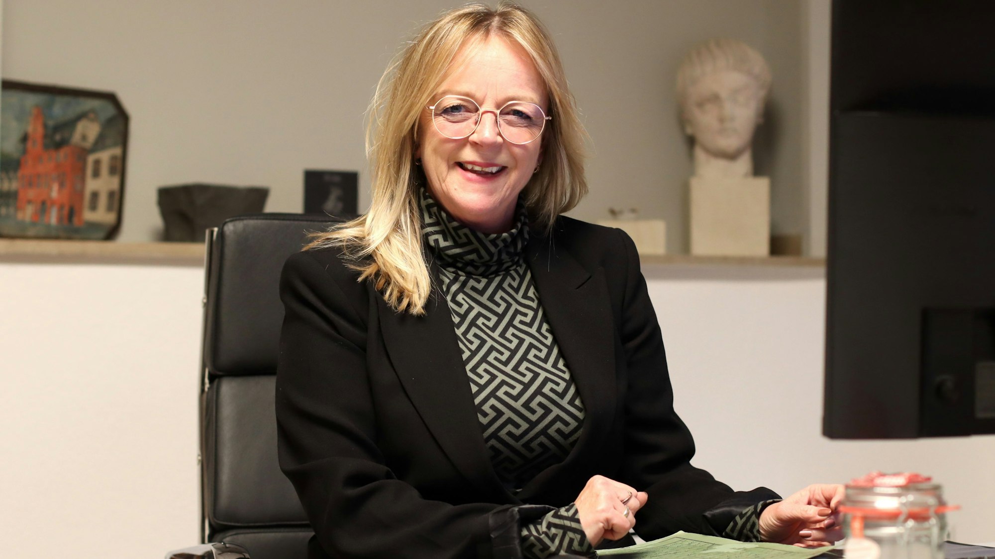 Sabine Preiser-Marian sitzt an einem Schreibtisch.