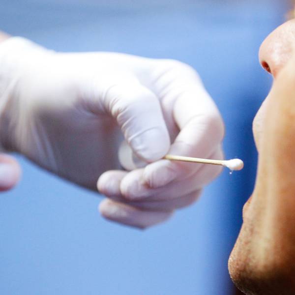 Die Polizei führt einen DNA-Speicheltest bei einem Mann (Polizist) in einem Mordfall durch.