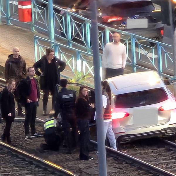 Ein Auto steht im Gleisbett der KVB, mehrere Menschen stehen darum