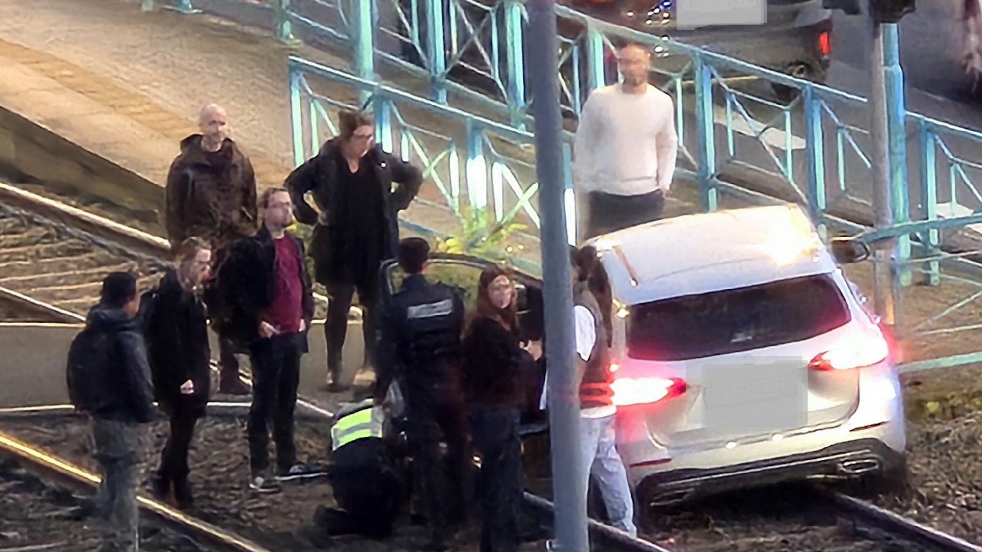 Ein Auto steht im Gleisbett der KVB, mehrere Menschen stehen darum