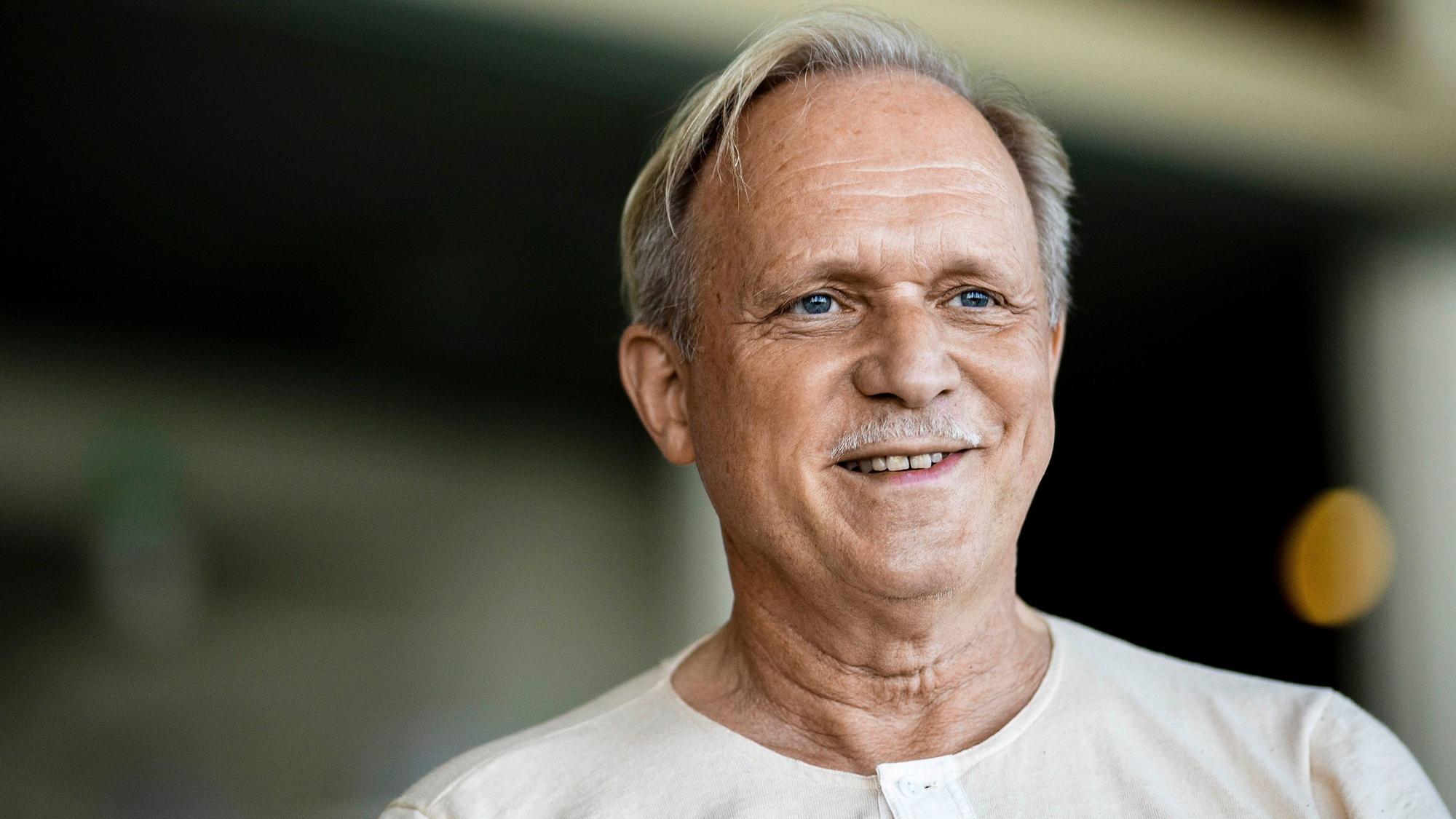 Ulrich Tukur lacht.