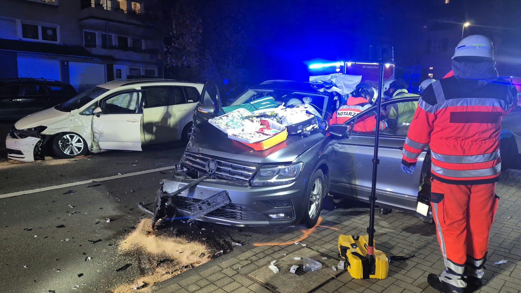 Rettungsdienstkräfte und Feuerwehr versorgen einen Verletzten in einem Unfallwagen.
