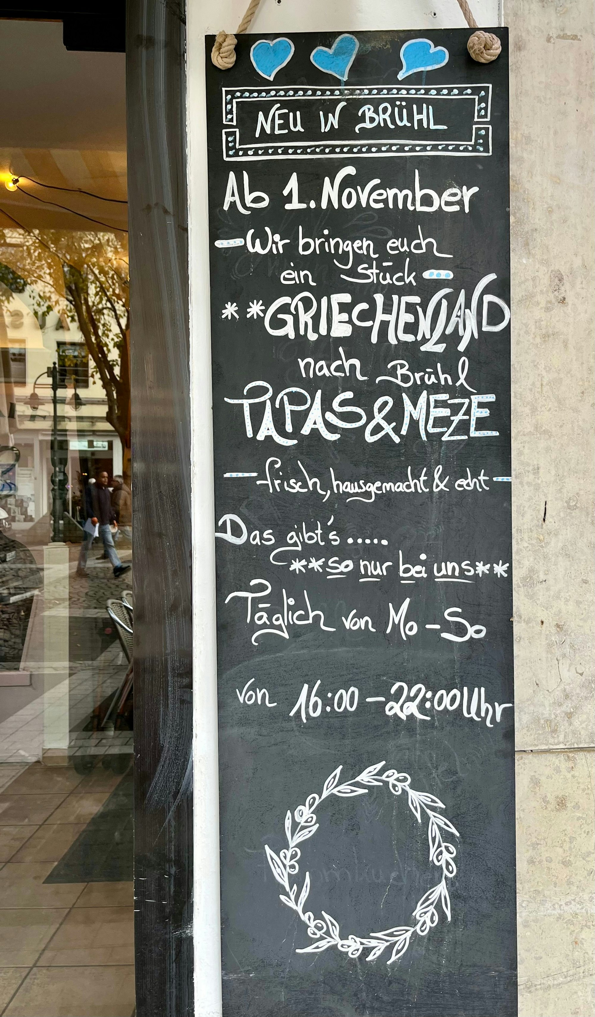 An der Wand ihres „Rosa Caffé“ wirbt Evelina Bennardo für ihr neues Konzept am Abend mit einer griechischen Küche.