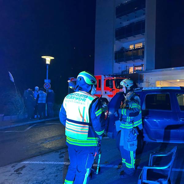 Feuerwehrleute stehen vor einem Haus an der Marienhöhe in Bergisch Gladbach.