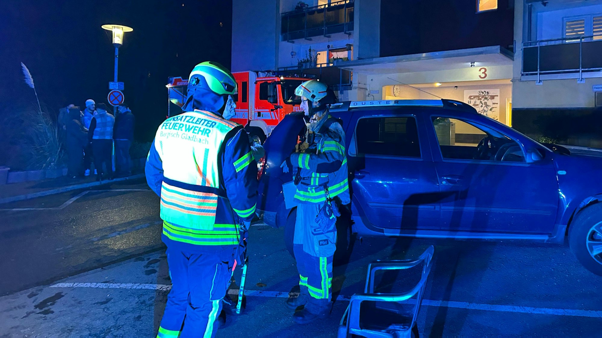 Feuerwehrleute stehen vor einem Haus an der Marienhöhe in Bergisch Gladbach.