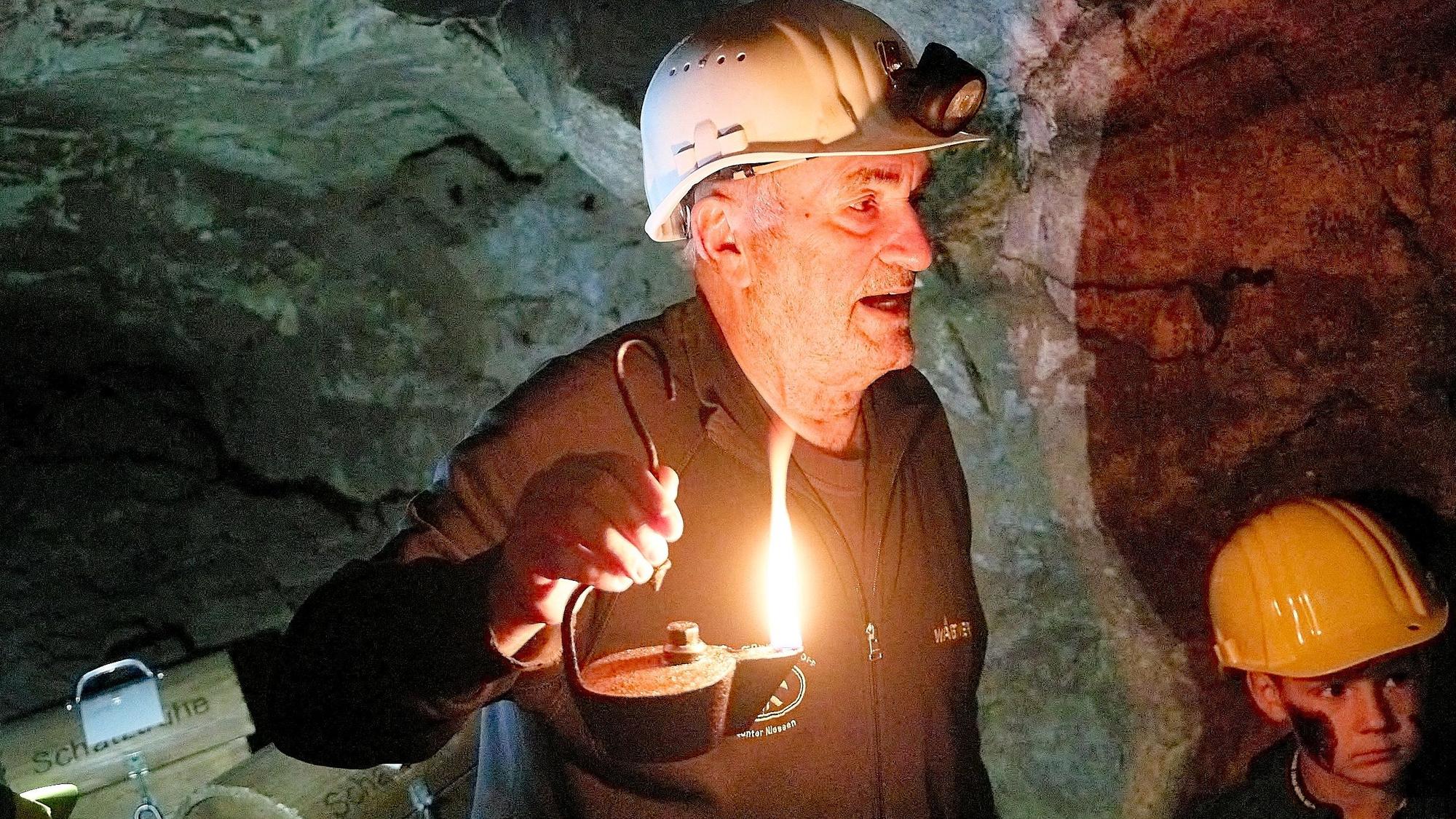 Günter Nießen, Vorsitzender des Fördervereins, mit einer Öllampe im Bergwerk.