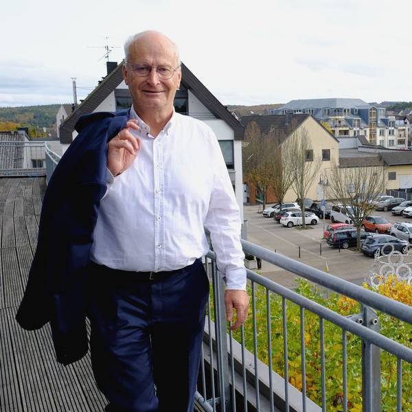 Bürgermeister Dr. Hans-Peter Schick steht mit leger über die Schulter geworfenem Jackett auf dem Rathausbalkon. Im Hintergrund ist die Mechernicher Innenstadt zu sehen.