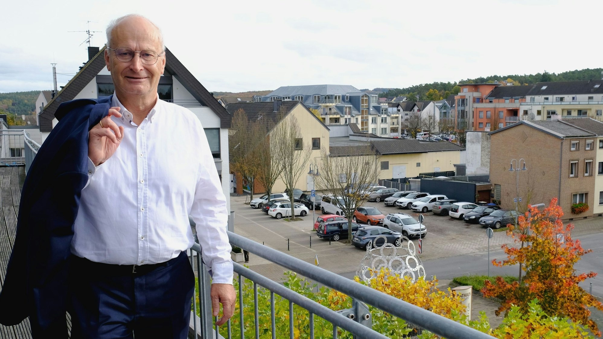 Bürgermeister Dr. Hans-Peter Schick steht mit leger über die Schulter geworfenem Jackett auf dem Rathausbalkon. Im Hintergrund ist die Mechernicher Innenstadt zu sehen.