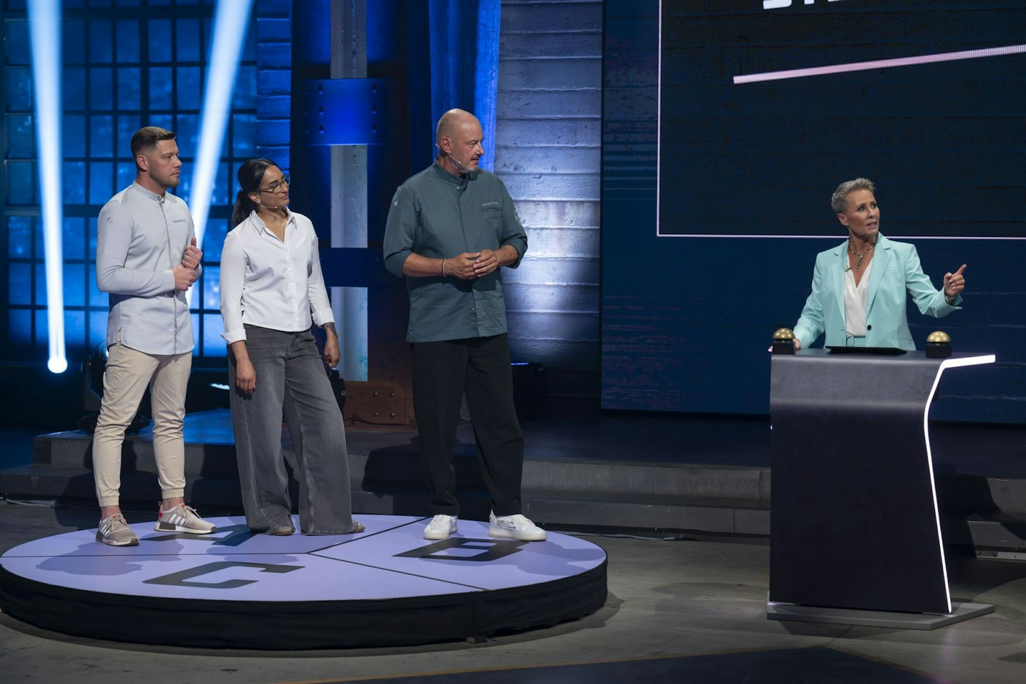 Moderatorin begrüßte „Team Rosin“ mit Kapitän Frank Rosin, Alina Meissner-Bebrout und Robin Pietsch als starke Herausforderer. Insgesamt hatten oder haben sie sechs Michelin-Sterne. (Bild: RTL/Markus Hertrich)