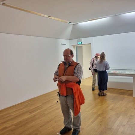 Ein sehbehinderter Mann steht in einem Kunstmuseum.