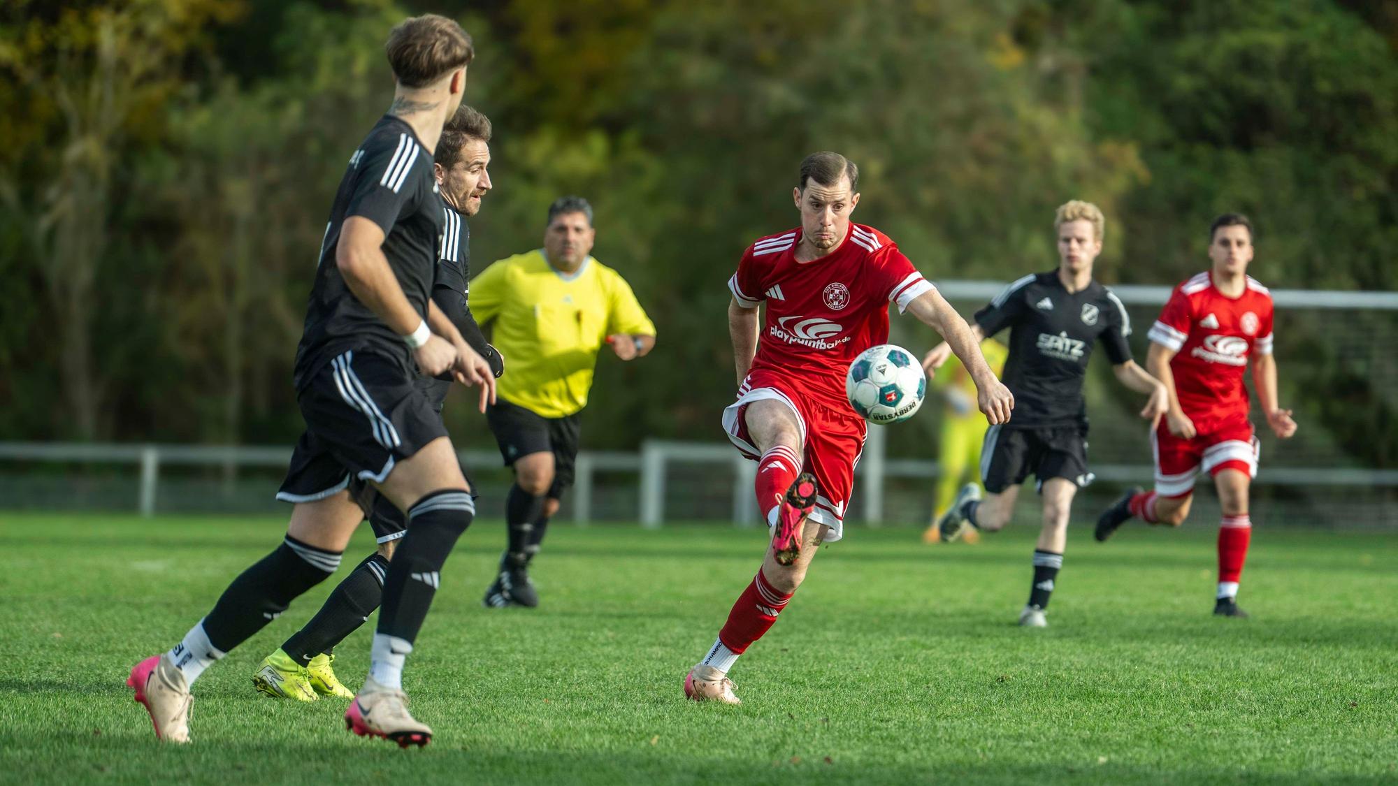 Beobachtet von zwei Frauenberger Spielern spielt Zülpichs Daniel Esser einen langen Ball.