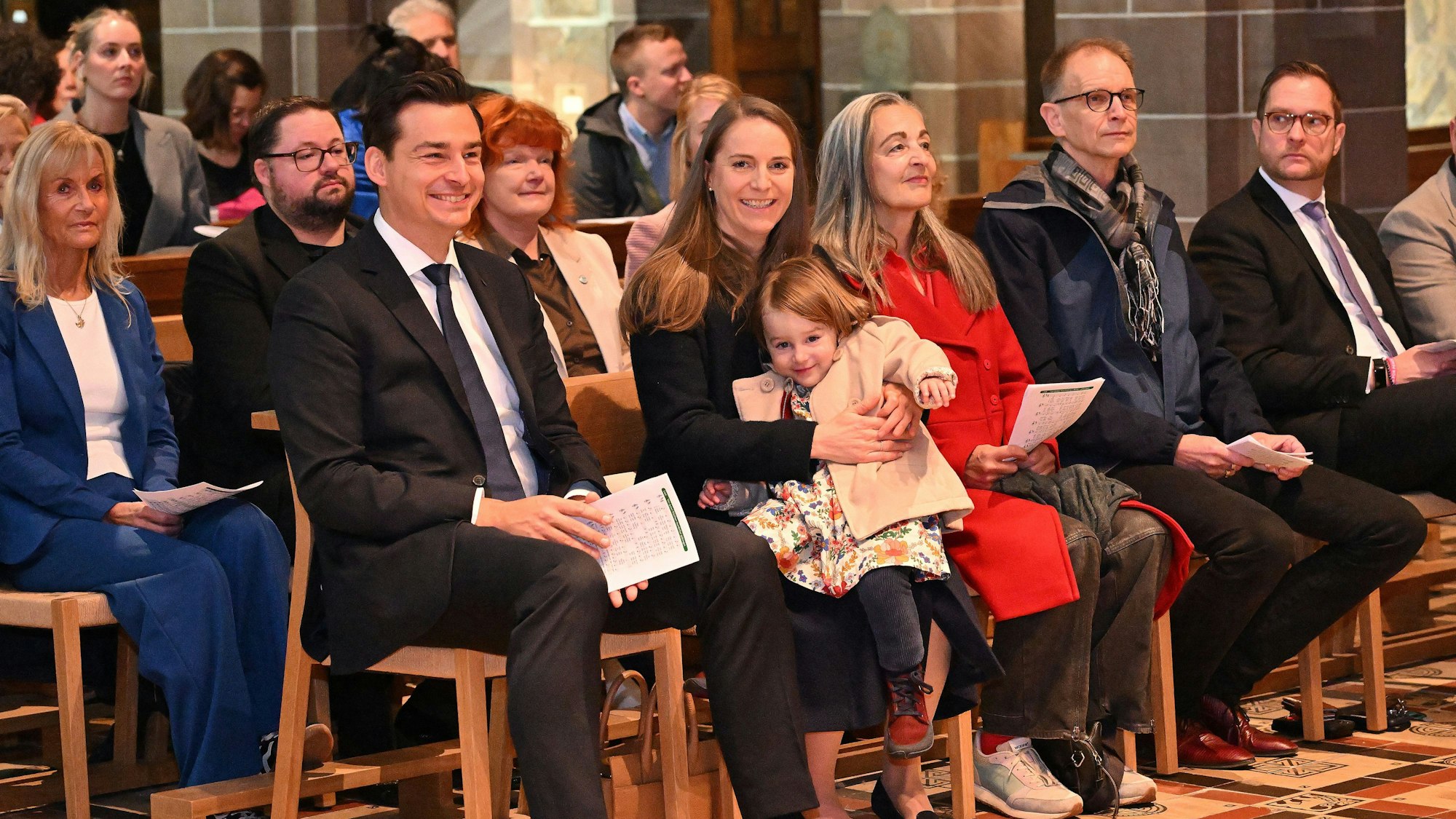Viele Menschen sitzen in einer Kirche.