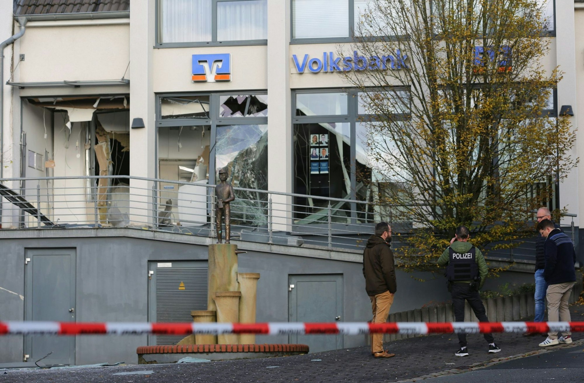 Ermittler der Polizei stehen in Paderborn vor einer beschädigten Bankfiliale.