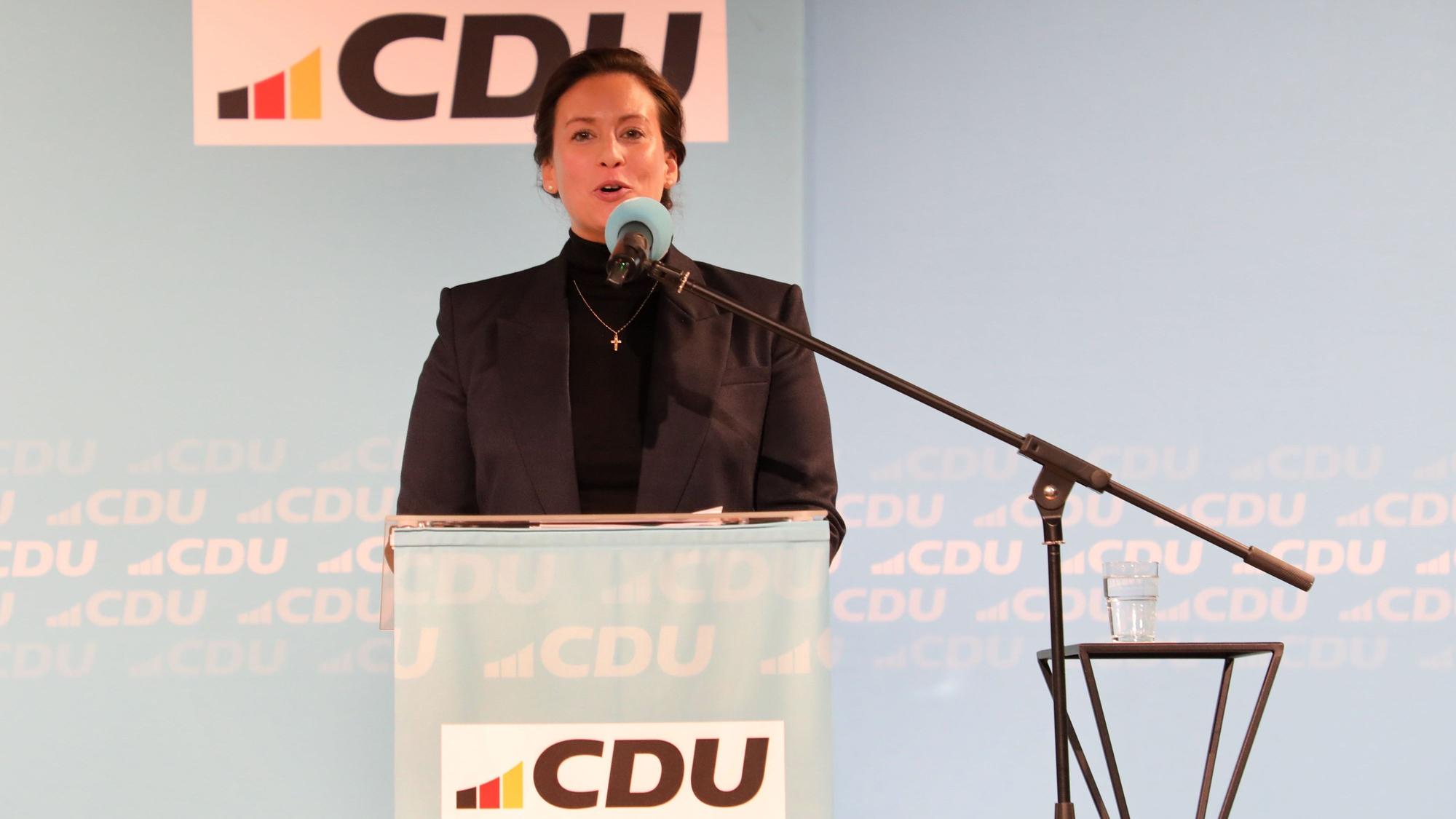 Caroline Bosbach steht am Mikrofon vor einer Wand mit CDU-Signet.