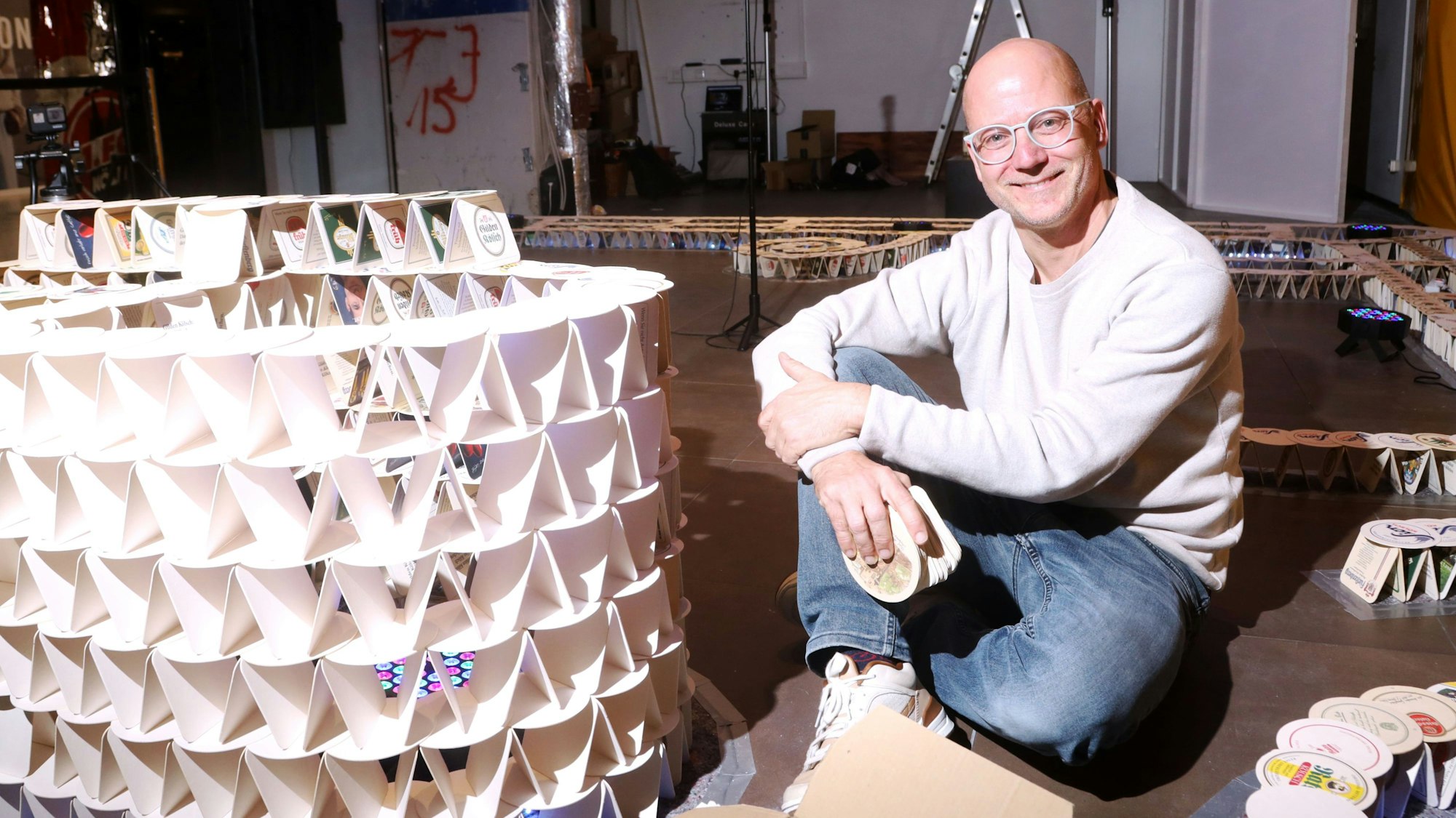 03.11.2025, Köln: Guinness-Weltrekordversuch mit 80.000 Bierdeckel im Rhein-Center. Der Pulheimer Benjamin Klapper wird im Laufe des Novembers ein monumentales Kunstwerk aus 80.000 Bierdeckeln errichten. Foto: Arton Krasniqi