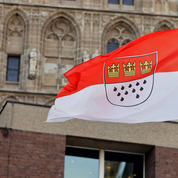 Eine Flagge am Rathaus zeigt die Kölner Farben Rot und Weiß sowie das Stadtwappen mit den drei Kronen und elf Tränen.