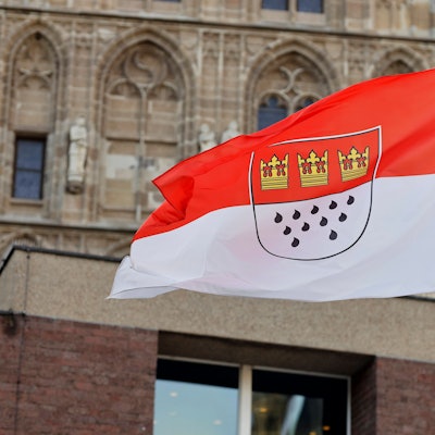 Eine Flagge am Rathaus zeigt die Kölner Farben Rot und Weiß sowie das Stadtwappen mit den drei Kronen und elf Tränen.