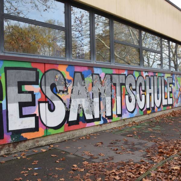 An der Fassade eines Flachbaus steht in großen Lettern Gesamtschule Holweide.