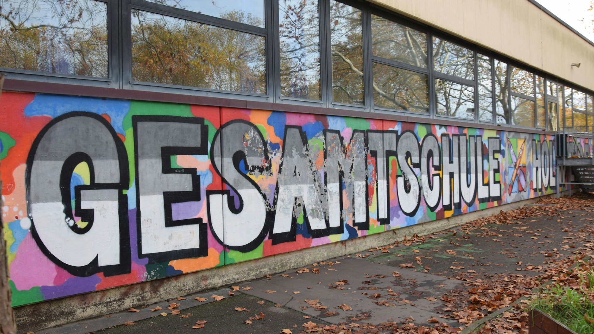 An der Fassade eines Flachbaus steht in großen Lettern Gesamtschule Holweide.