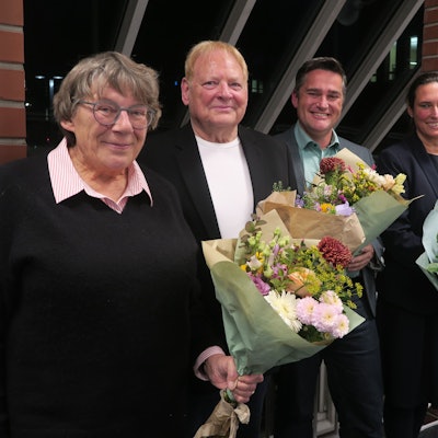 Zwei Frauen und zwei Männer stehen mit Blumensträußen in der Hand nebeneinander.