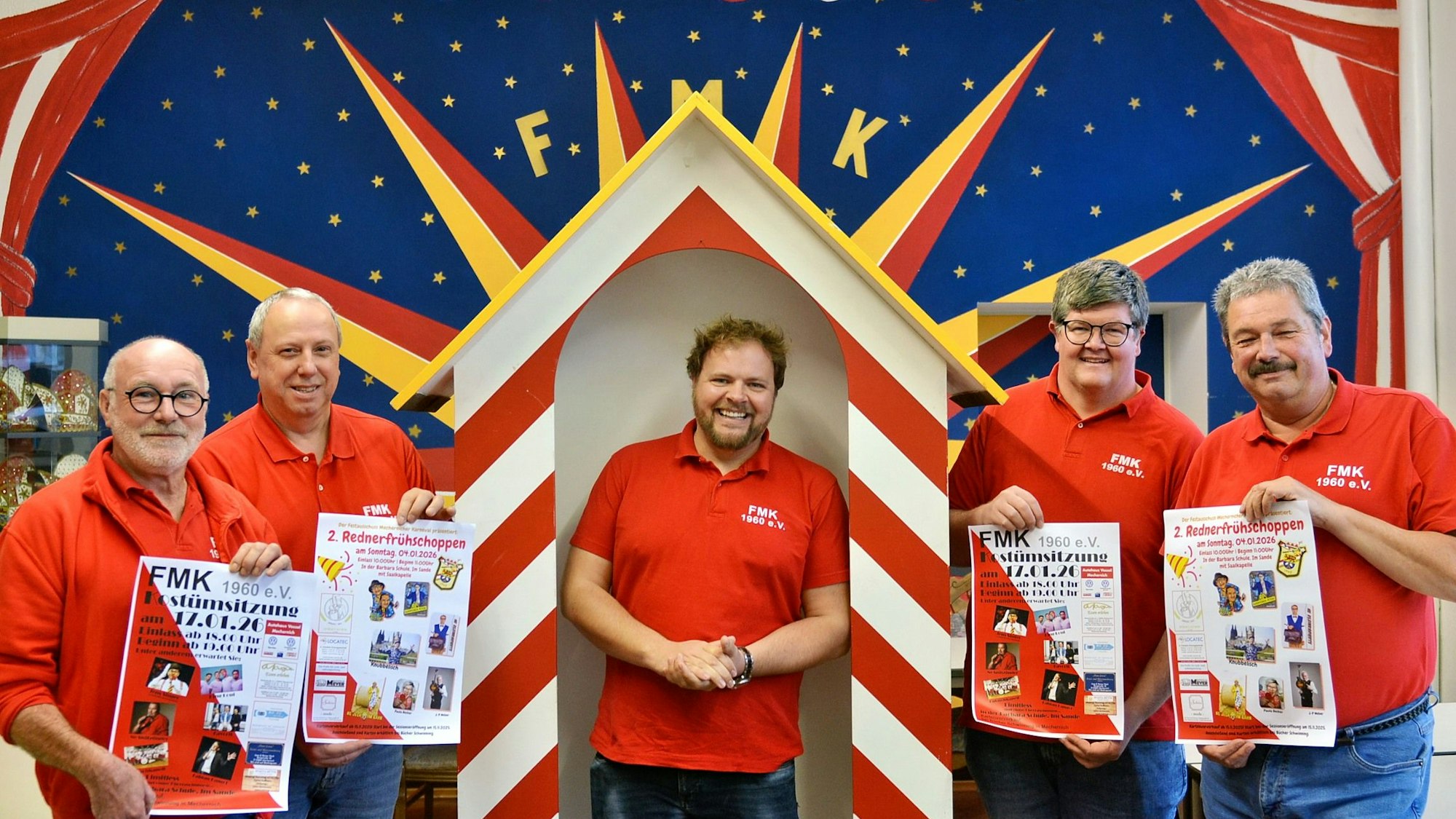 Männer in roten Poloshirts präsentieren Karnevals-Plakate. In der Mitte steht der zukünftige Prinz Torsten Krieg.