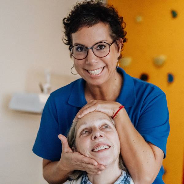 Eine Physiotherapeutin behandelt eine Patientin.