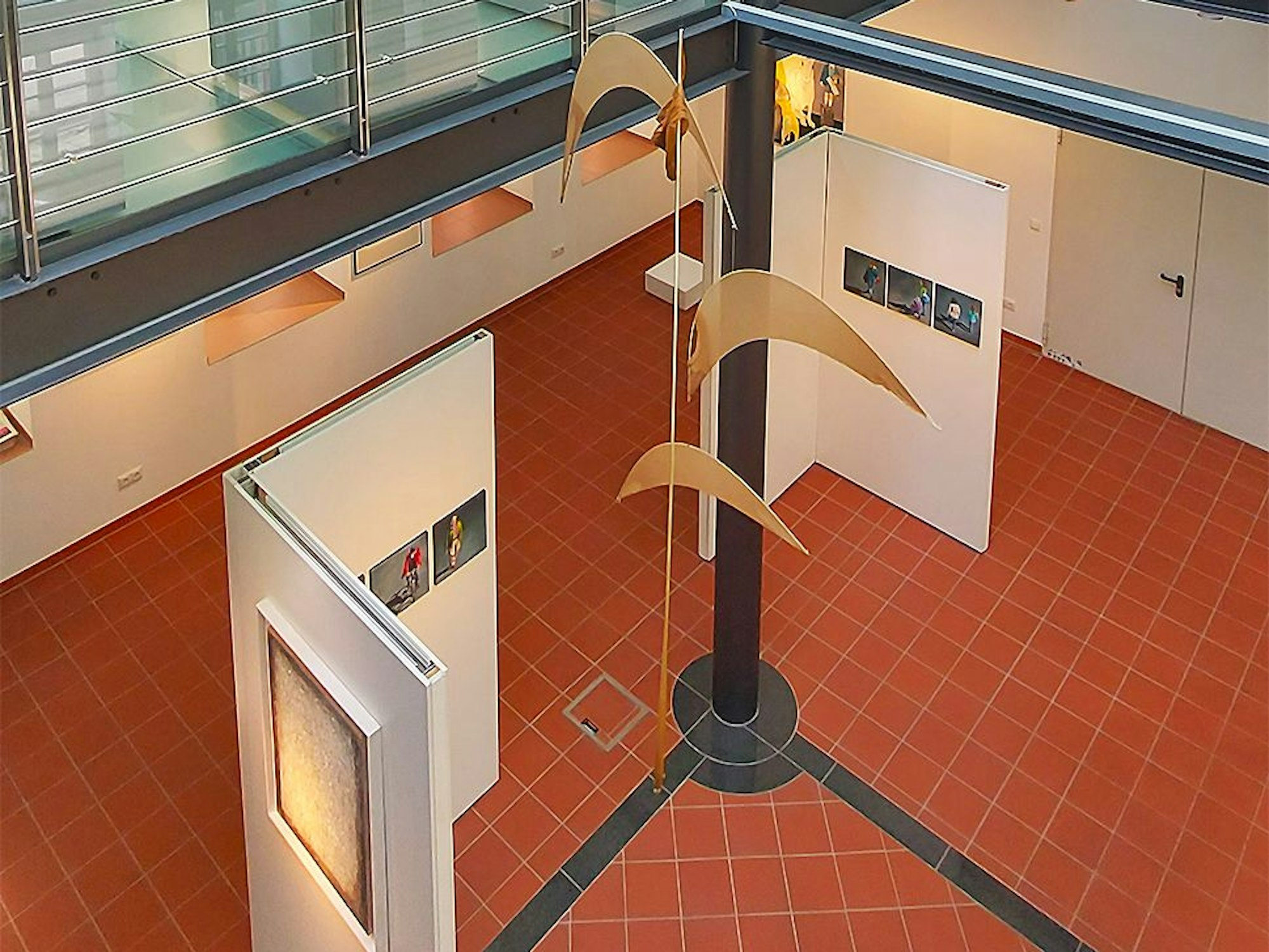 Das Bild zeigt Ausstellungswände im Kunstforum Eifel und ein großes Mobile, das von der Decke herabhängt.