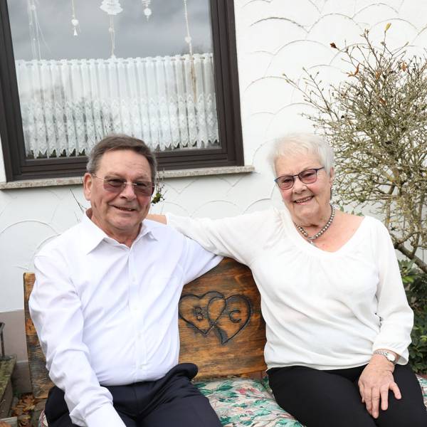 Ein Mann und eine Frau auf einer Holzbank.