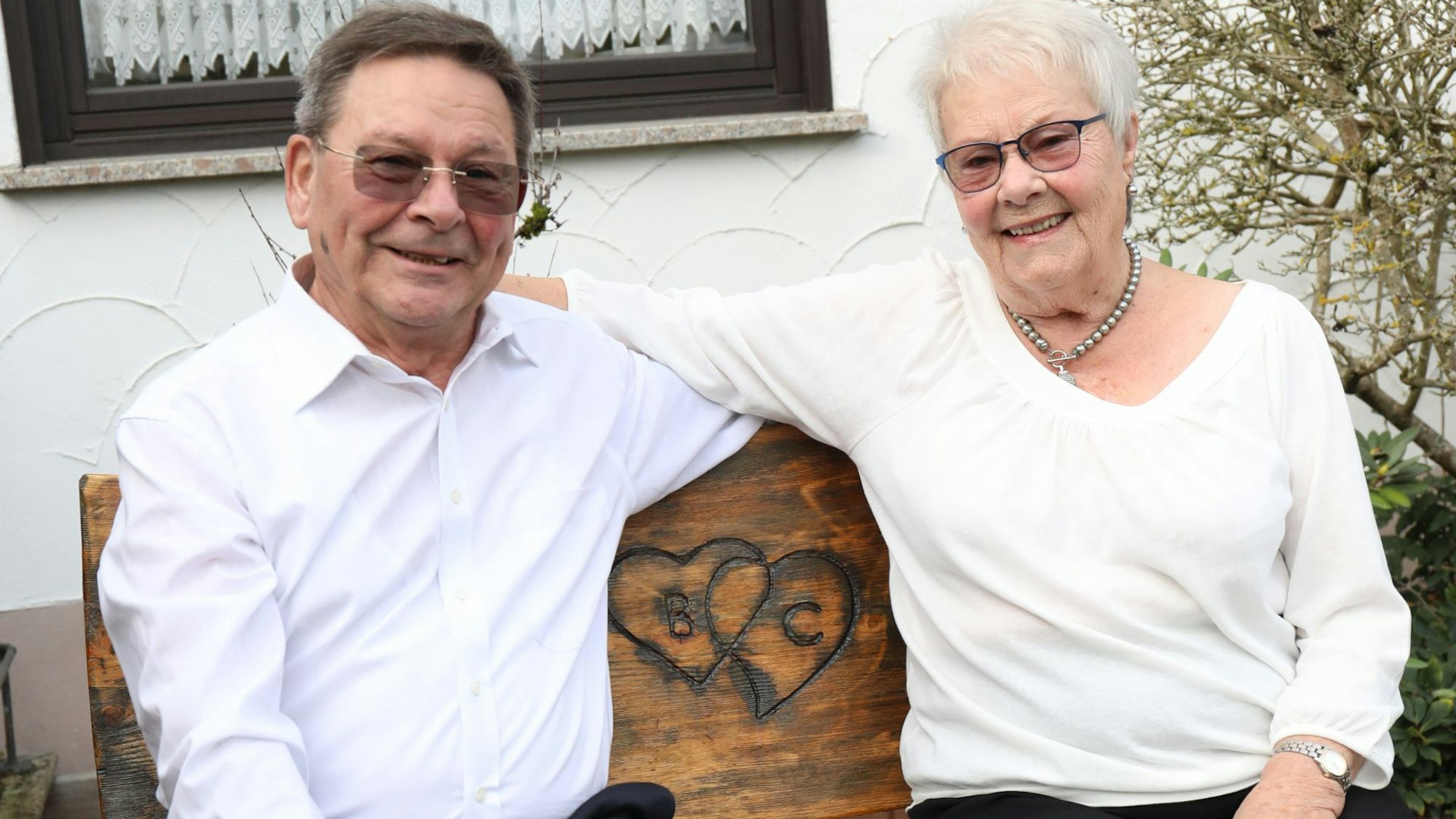 Ein Mann und eine Frau auf einer Holzbank.