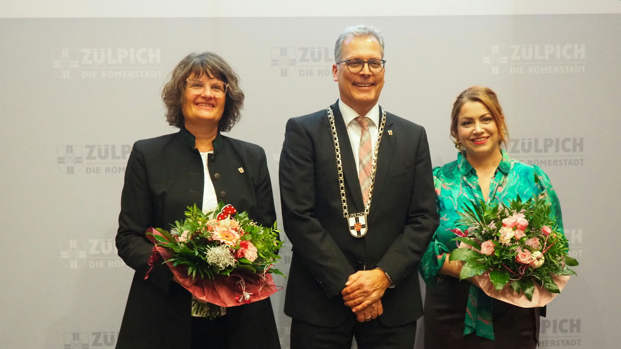 Das Bild zeigt Ulf Hürtgen mit Amtskette. Er wird von Silvia Wallraff und Isabella Meurer flankiert.