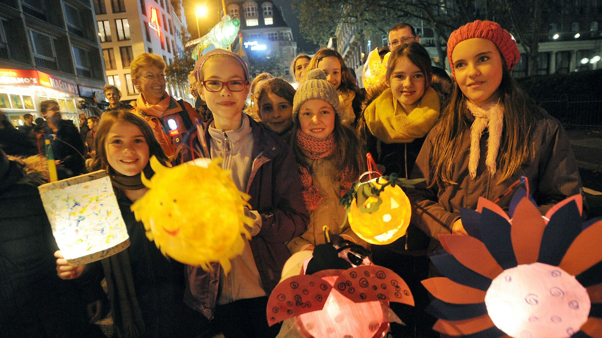 Kinder halten am 08.11.2013 in Köln (Nordrhein-Westfalen) bei einem Martinszug in der Innenstadt ihre Laternen.