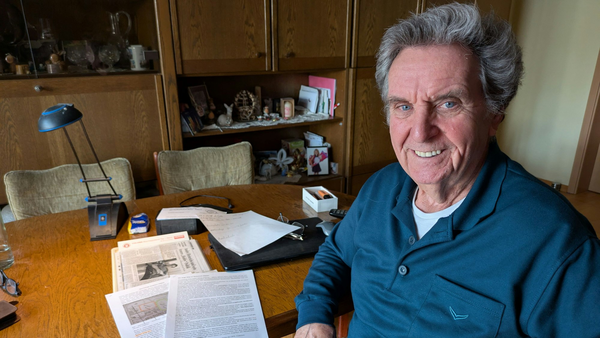 André Heinrichs sitzt am heimischen Wohnzimmertisch und lächelt in die Kamera.