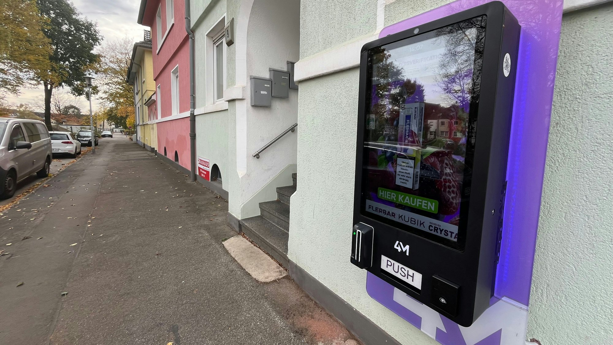 An einer Hauswand in der Manforter Luisenstraße hängt der Automat, direkt gegenüber ist ein Kinderspielplatz