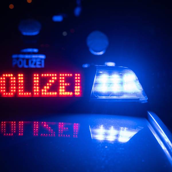 Zwei Polizisten stehen im Rahmen eines Fototermins vor einem Polizeifahrzeug.