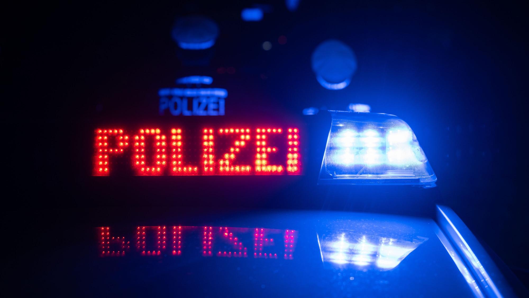 Zwei Polizisten stehen im Rahmen eines Fototermins vor einem Polizeifahrzeug.