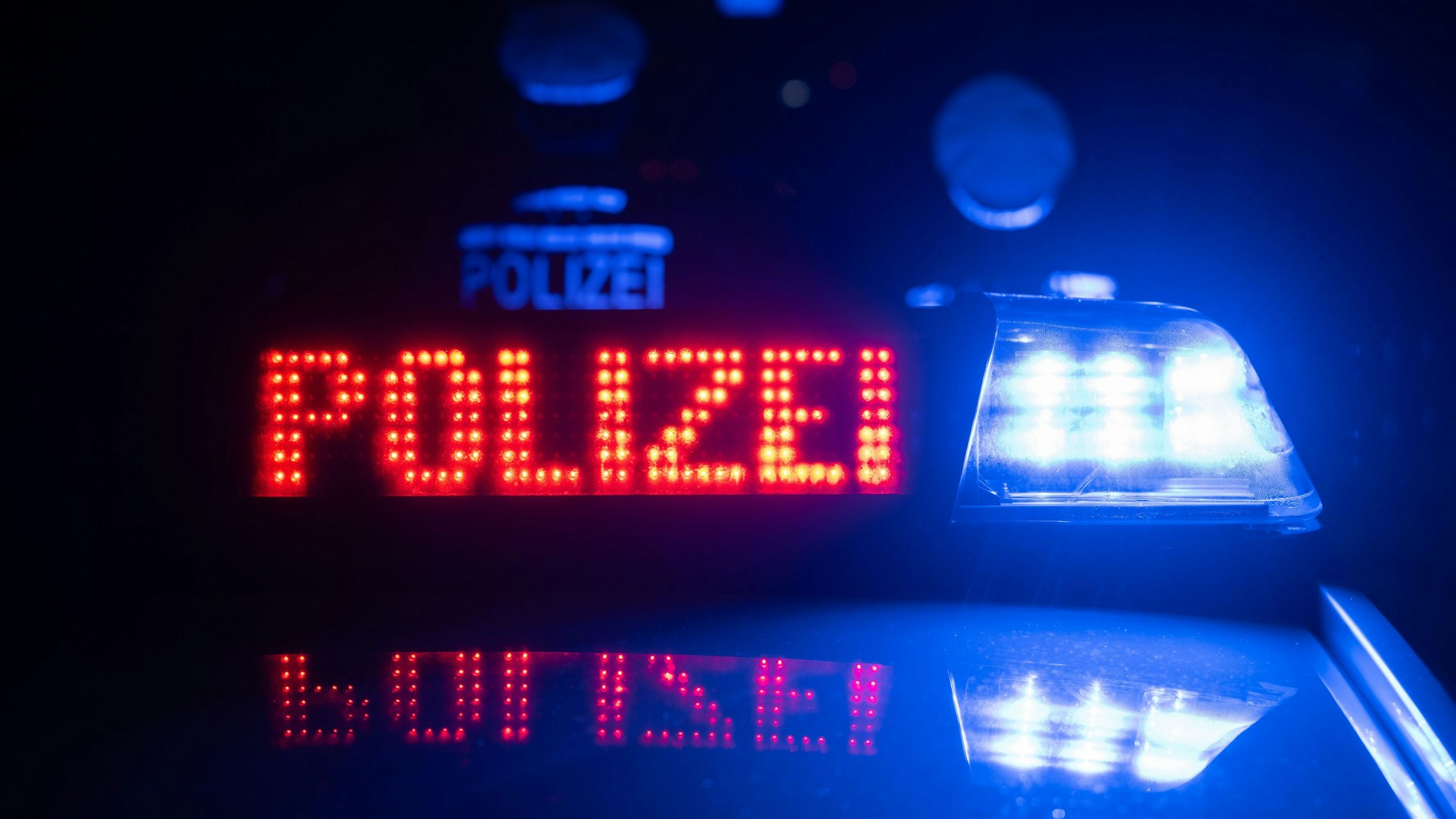 Zwei Polizisten stehen im Rahmen eines Fototermins vor einem Polizeifahrzeug (gestellte Szene). (zu dpa: «Einbruch in Schützenvereinshaus - Waffen und Munition entwendet») +++ dpa-Bildfunk +++