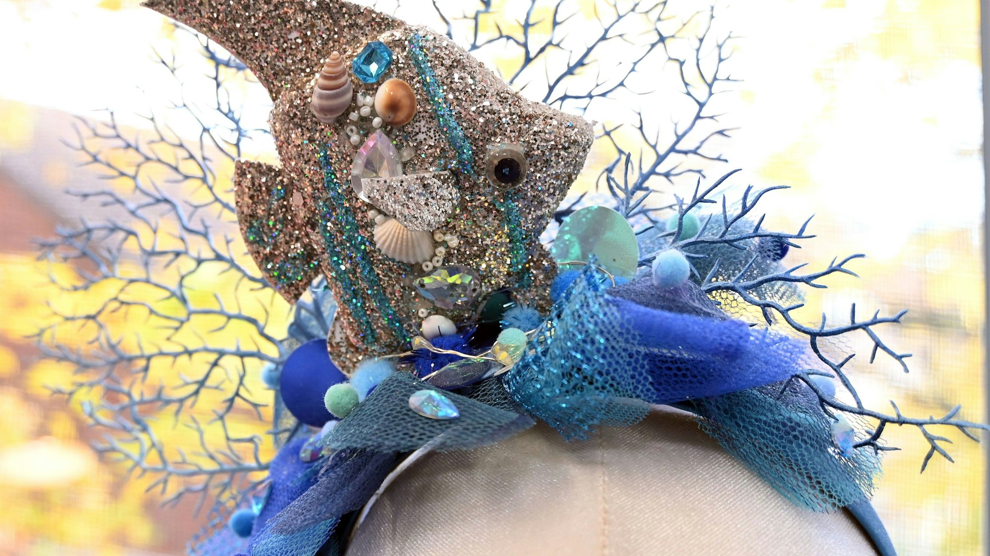 Ein Haarreif mit Fisch und Korallenelementen ist auf einem Kunstkopf arrangiert.