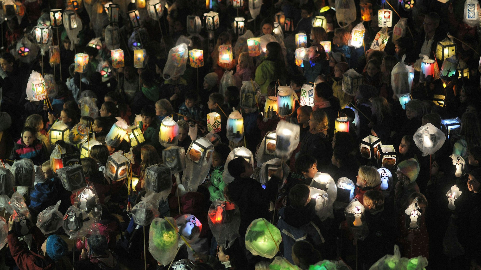 Kinder halten am 07.11.2013 in Köln (Nordrhein-Westfalen) beim Martinszug der Montessori Grundschule Am Pistorhof ihre Laternen.