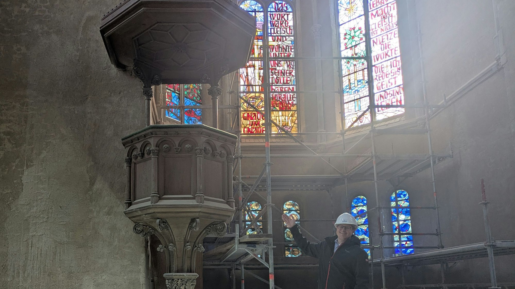 Ein Mann steht in einer Kirche, die restauriert wird.