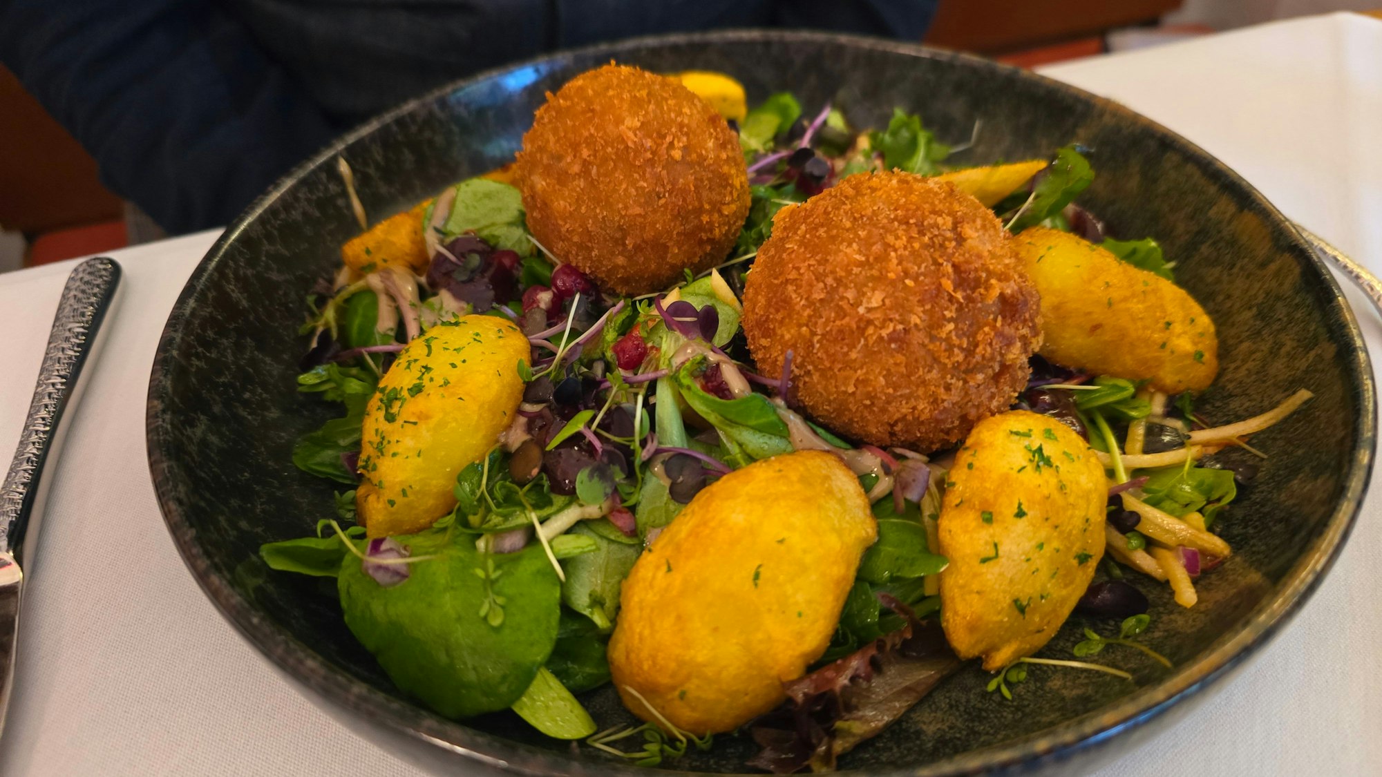 Tellergericht mit panierten Pilzklößen, Blattsalat und angebratenen Kartoffeln