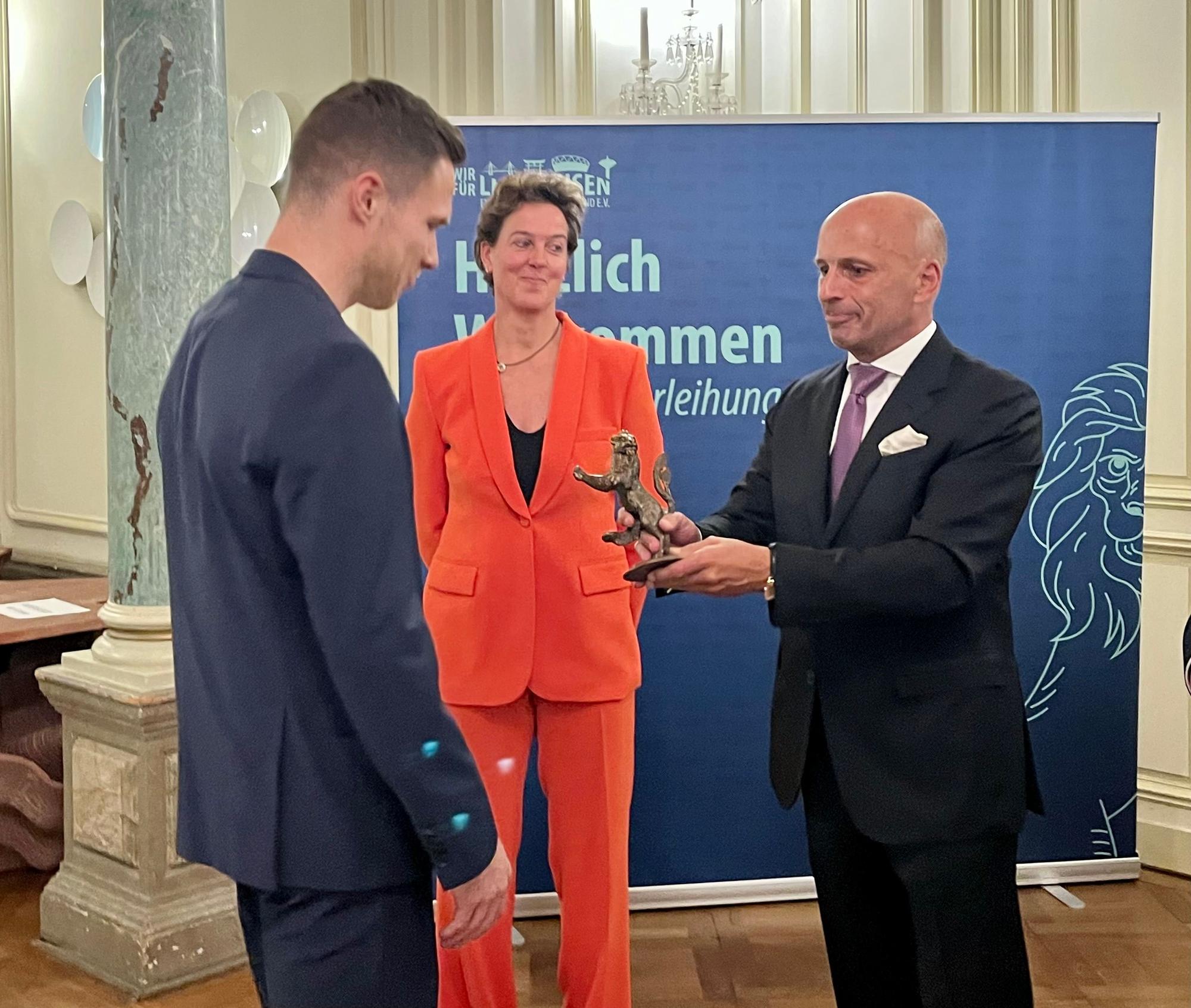Feierliche Übergabe: Rehm erhält von Uwe Beenen die Bronze-Skulptur, geschaffen vom Leverkusener Künstler Kurt Arentz.