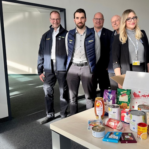 Klaus-Dieter Voos vom THW, Alexander Kohrs (Metro), Schirmherr Stefan Hebbel, Adolf Staffe von der Tafel und Nathalie-Patricia Moneta (Metro) mit dem Weihnachtspaket für 2025