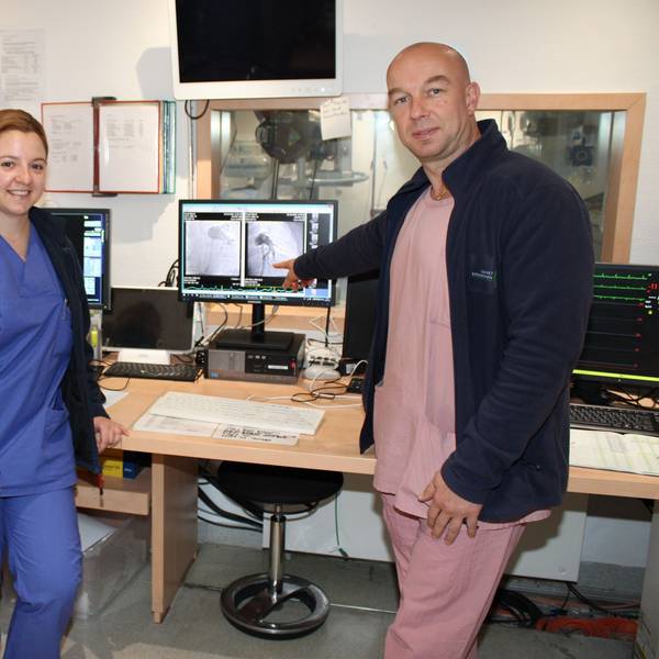 Auf dem Bild sind drei Ärzte vor medizinischen Geräten in einem Krankenhaus zu sehen.