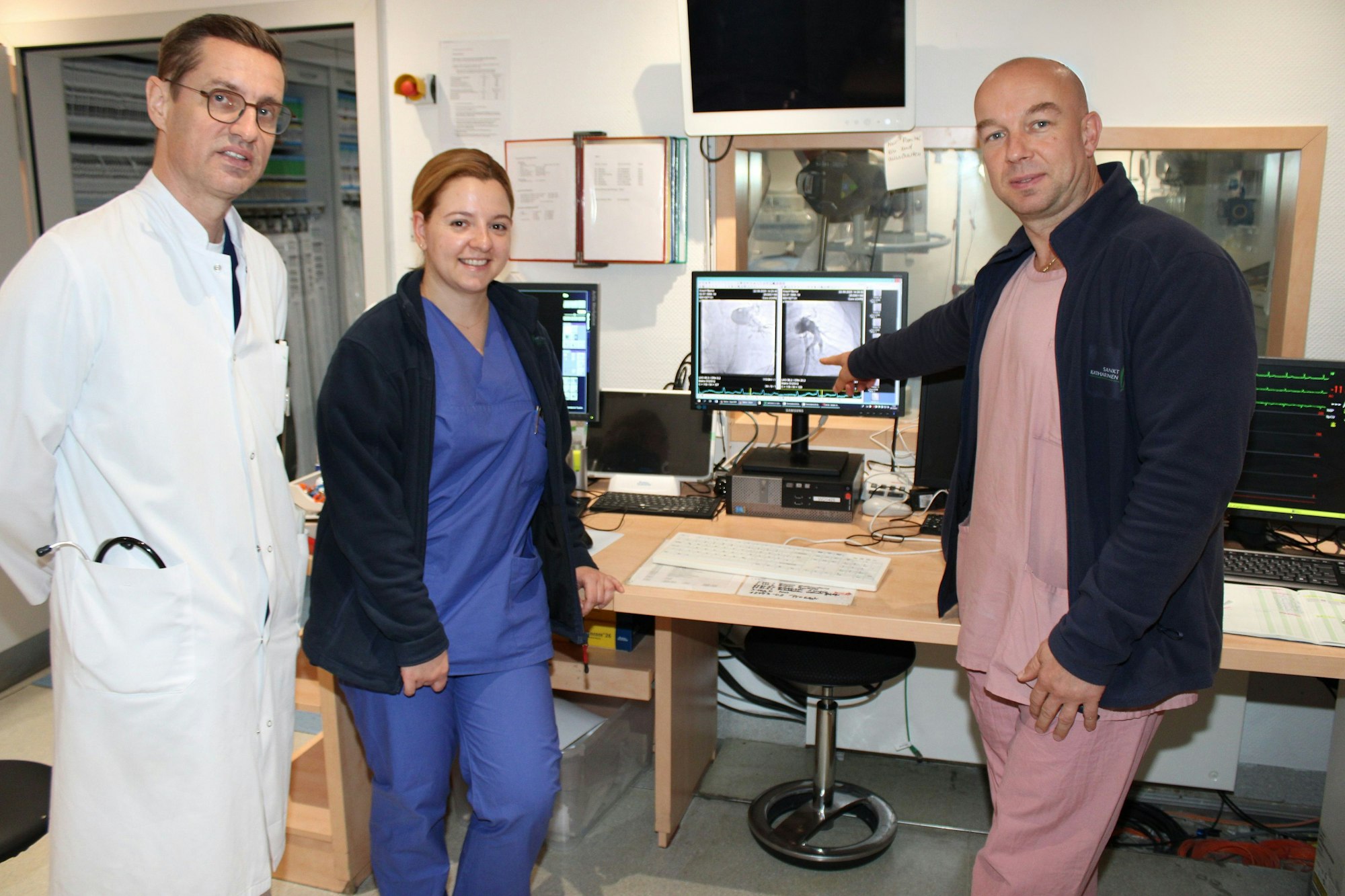 Auf dem Bild sind drei Ärzte vor medizinischen Geräten in einem Krankenhaus zu sehen.