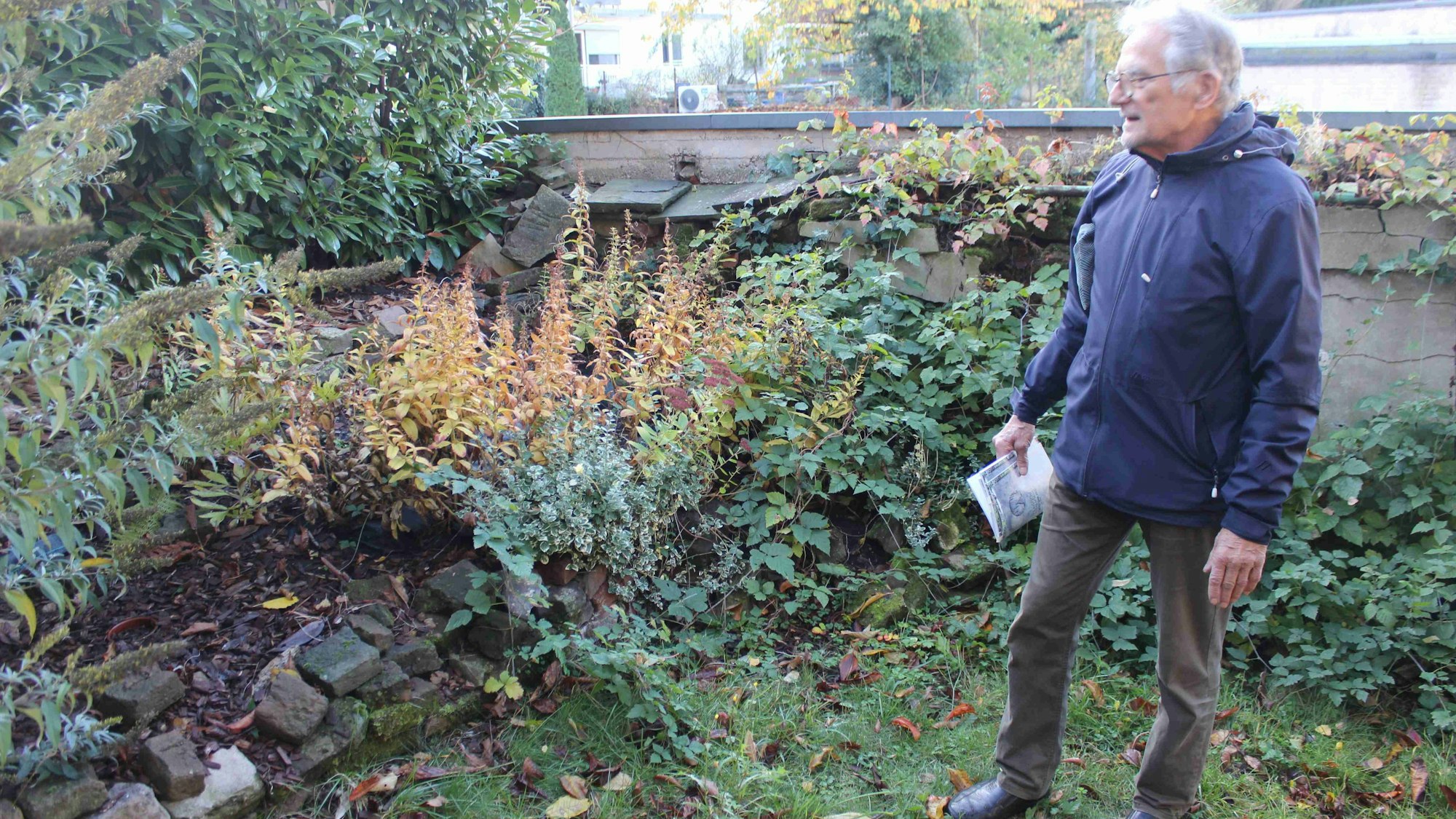 Helmut Goldau im Garten von Edith Grziwa an Mauerresten der 1838 verwüsteten Mülheimer Synagoge.