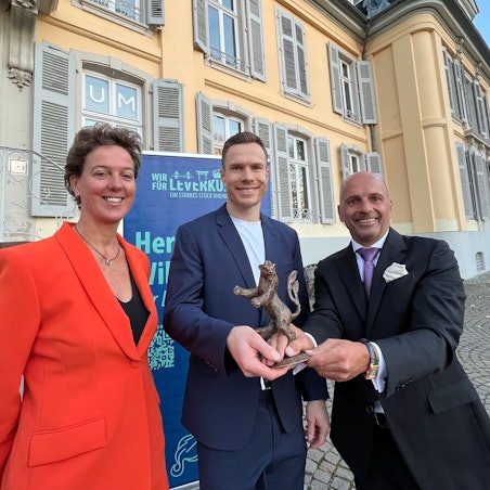 Der Leverkusener Löwe 2025 wird von Steffi Nerius und Uwe Beenen an Markus Rehm übergeben.