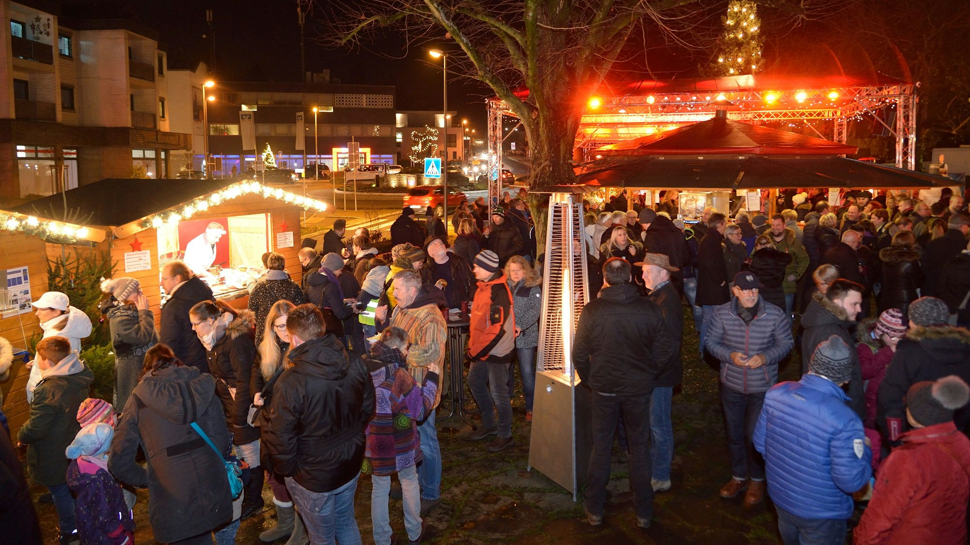 Menschen stehen und erzählen am Abend auf dem Weihnachtsmarkt Overath.