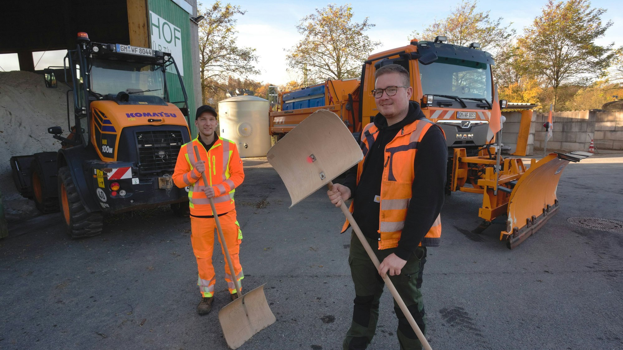 Das Foto zeigt zwei Mitarbeiter des Bauhofs Wipperfürth-Hückeswagen und im Hintergrund einen Schneepflug.